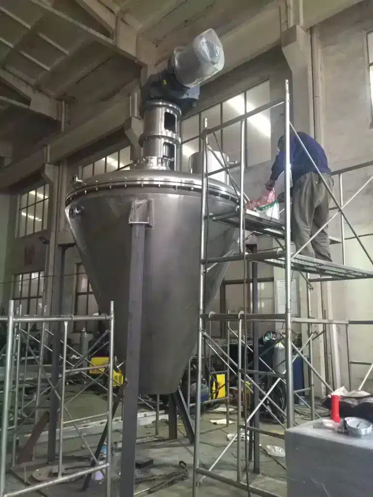 Stainless steel industrial conical ribbon screw blender mixer under construction in factory workshop