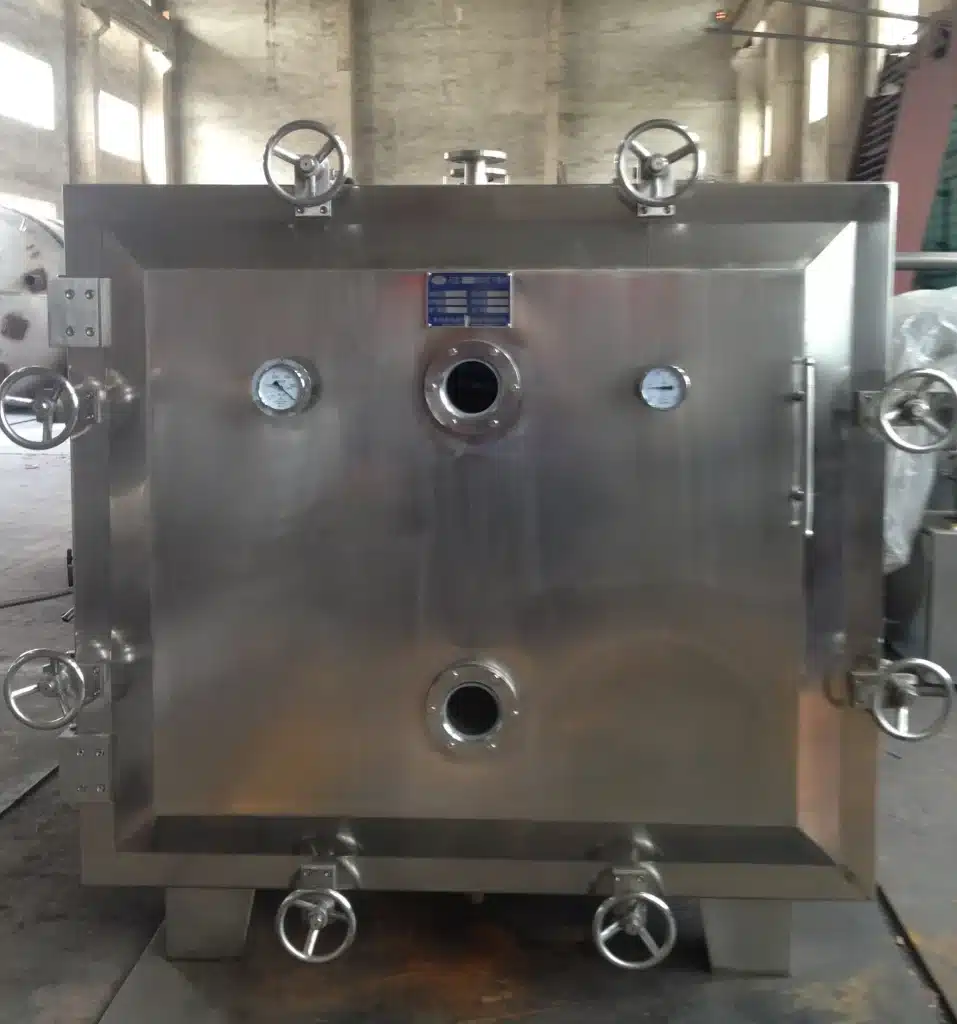 A Static Vacuum Cabinet Dryer with a stainless steel rectangular body, multiple round pressure gauges, and ports on the front, mounted on sturdy legs with casters.